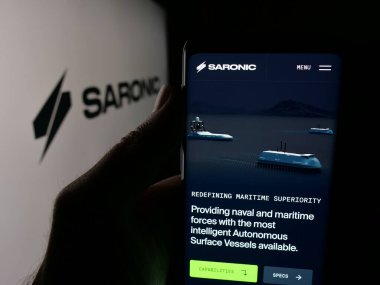 Stuttgart, Almanya - 10-22-2025: ABD 'li savunma şirketi Saronic Technologies' in web sayfası olan akıllı telefon sahibi kişi logonun önünde ekranda. Telefon ekranının merkezine odaklan.