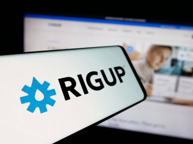 Stuttgart, Almanya - 10-24-2025: İnternet sitesi önünde ekranda ABD 'li enerji yazılım şirketi RigUp Inc.' in logosuna sahip akıllı telefon. Telefon ekranının merkez soluna odaklan.
