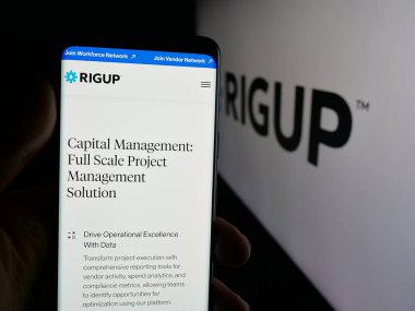 Stuttgart, Almanya - 10-24-2025: ABD 'li enerji yazılım şirketi RigUp Inc.' in web sayfası olan cep telefonu logonun önünde ekranda. Telefon ekranının merkezine odaklan.