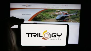Stuttgart, Almanya - 10-24-2025: Kanadalı maden şirketi Trilogy Metals Inc. 'in logosunun bulunduğu cep telefonu web sayfasının önünde ekranda. Telefon ekranına odaklan.