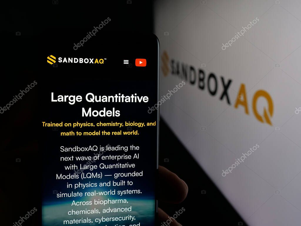 Stuttgart, Germany - 10-20-2025: Person holding smartphone with web page of US company SB Technology Inc. (SandboxAQ) on screen in front of logo. Focus on center of phone display.