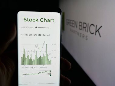 Stuttgart, Almanya - 10-27-2025: Ev yapım şirketi Green Brick Partners Inc. 'in web sayfası olan akıllı telefon sahibi kişi logonun önünde ekranda. Telefon ekranının merkezine odaklan.