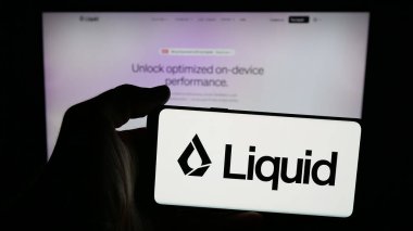 Stuttgart, Almanya - 10-27-2025: Web sayfasının önünde ABD 'li yapay zeka şirketi Liquid AI' nin logosunun bulunduğu cep telefonu sahibi kişi. Telefon ekranına odaklan.