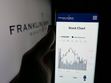 Stuttgart, Almanya - 10-30-2025: ABD 'li Franklin BSP Emlak Şirketi' nin web sayfası ile akıllı telefon sahibi kişi logonun önünde ekranda. Telefon ekranının merkezine odaklan.