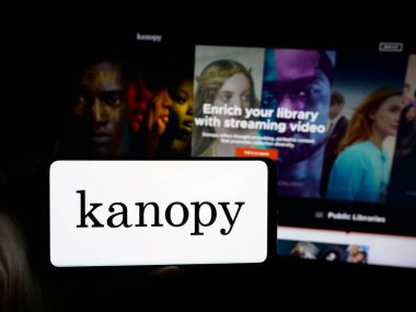 Stuttgart, Almanya - 10-30-2025: ABD 'li video yayın platformu şirketi Kanopy' nin logosuna sahip akıllı telefon sahibi kişi web sitesinin önünde ekranda. Telefon ekranına odaklan.