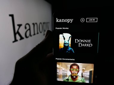 Stuttgart, Almanya - 10-30-2025: ABD 'li video yayın platformu şirketi Kanopy' nin web sayfası olan akıllı telefon sahibi kişi logonun önünde ekranda. Telefon ekranının merkezine odaklan.