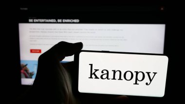 Stuttgart, Almanya - 10-30-2025: ABD video yayın platformu şirketi Kanopy 'nin logosuna sahip cep telefonu sahibi kişi web sayfasının önünde ekranda. Telefon ekranına odaklan.