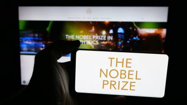 Stuttgart, Almanya - 10-30-2025: Web sayfası önündeki ekranda Nobel Ödülleri logosu bulunan cep telefonu sahibi kişi. Telefon ekranına odaklan.