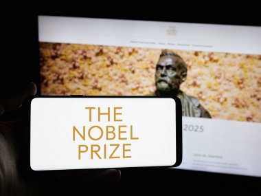 Stuttgart, Almanya - 10-30-2025: Web sitesi önünde Nobel Ödülleri logosu olan akıllı telefon sahibi kişi. Telefon ekranına odaklan.