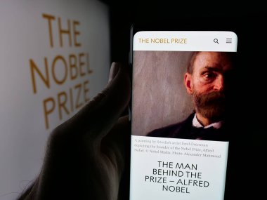 Stuttgart, Almanya - 10-30-2025: Logonun önünde Nobel Ödülleri web sayfası bulunan akıllı telefon sahibi kişi. Telefon ekranının merkezine odaklan.