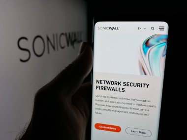 Stuttgart, Almanya - 10-30-2025: ABD 'li siber güvenlik şirketi SonicWall Inc.' in web sayfası ile akıllı telefon sahibi kişi logonun önünde ekranda. Telefon ekranının merkezine odaklan.