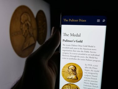 Stuttgart, Almanya - 10-30-2025: ABD gazetecilik ödülleri web sayfası bulunan akıllı telefon sahibi kişi logonun önünde ekranda Pulitzer Ödülleri 'ni sunuyor. Telefon ekranının merkezine odaklan.