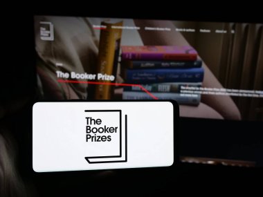 Stuttgart, Almanya - 10-30-2025: İnternet sitesi önünde İngiliz Edebiyat Ödülü Booker Ödülü logosu olan akıllı telefon sahibi kişi. Telefon ekranına odaklan.