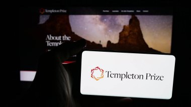 Stuttgart, Almanya - 10-31-2025: İnternet sayfası önünde yıllık Templeton Ödülü logosu bulunan cep telefonu sahibi kişi. Telefon ekranına odaklan.