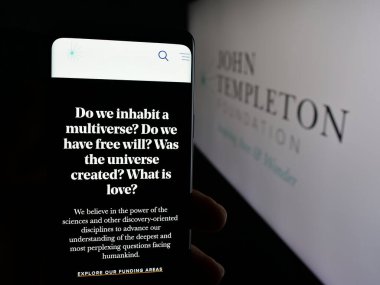 Stuttgart, Almanya - 10-31-2025: ABD kuruluşu John Templeton Foundation 'ın web sayfası ile birlikte logo önünde cep telefonu tutan kişi. Telefon ekranının merkezine odaklan.