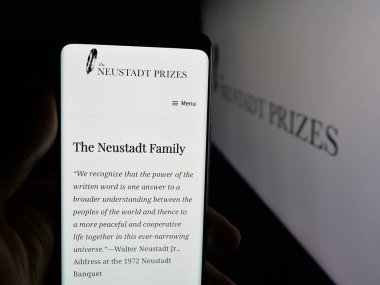 Stuttgart, Almanya - 10-31-2025: Cep telefonu Neustadt Uluslararası Edebiyat Ödülü 'nün web sayfası logonun önünde duruyor. Telefon ekranının merkezine odaklan.