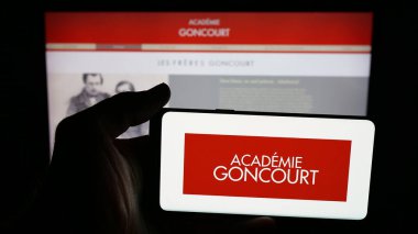 Stuttgart, Almanya - 10-31-2025: Fransız örgütü Academie Goncourt 'un logosunun bulunduğu cep telefonu web sayfası önünde ekranda. Telefon ekranına odaklan.