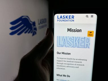 Stuttgart, Almanya - 10-31-2025: Bilim kuruluşu Lasker Foundation 'ın web sayfası olan akıllı telefonu logo önünde ekranda tutan kişi. Telefon ekranının merkezine odaklan.