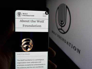 Stuttgart, Almanya - 10-31-2025: İsrail örgütü The Wolf Foundation 'ın logo önündeki web sayfası ile cep telefonu tutan kişi. Telefon ekranının merkezine odaklan.