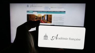 Stuttgart, Almanya - 10-31-2025: Fransız örgütü Academie Francaise 'in logosunun bulunduğu cep telefonu web sayfası önünde ekranda. Telefon ekranına odaklan.
