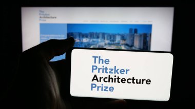 Stuttgart, Almanya - 10-31-2025: İnternet sayfası önünde üzerinde Pritzker Mimarlık Ödülü logosu bulunan cep telefonu sahibi kişi. Telefon ekranına odaklan.