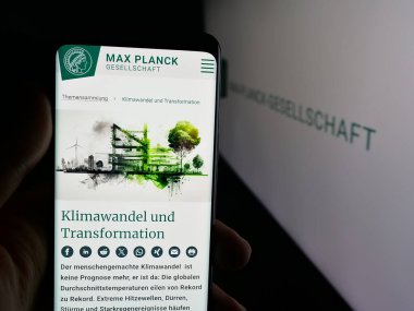 Stuttgart, Almanya - 11-01-2025: Araştırma kuruluşu Max-Planck-Gesellschaft 'ın web sayfası olan akıllı telefonu logo önünde ekranda tutan kişi. Telefon ekranının merkezine odaklan.