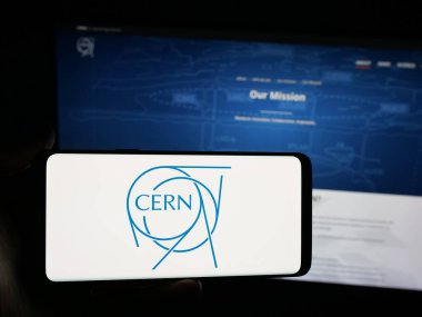 Stuttgart, Almanya - 11-01-2025: İnternet sitesi önünde Avrupa nükleer araştırma kuruluşu CERN 'in logosuna sahip akıllı telefon sahibi kişi. Telefon ekranına odaklan.