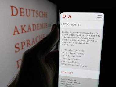 Stuttgart, Almanya - 11-01-2025: Sosyete Amerikan Sanat ve Edebiyat Akademisi web sitesi logosu önünde cep telefonu tutan kişi. Telefon ekranının merkezine odaklan.