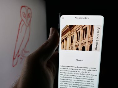 Stuttgart, Almanya - 11-01-2025: Sosyete Amerikan Sanat ve Edebiyat Akademisi web sitesi logosu önünde cep telefonu tutan kişi. Telefon ekranının merkezine odaklan.