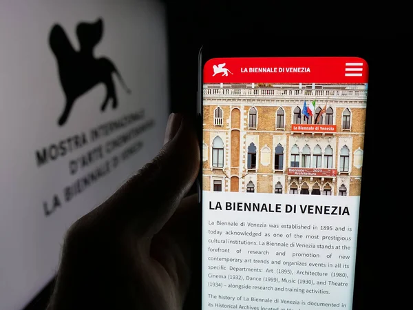 Stuttgart, Almanya - 10-31-2025: Venedik Film Festivali 'nin (Biennale) web sayfası logonun önünde duran kişi. Telefon ekranının merkezine odaklan.