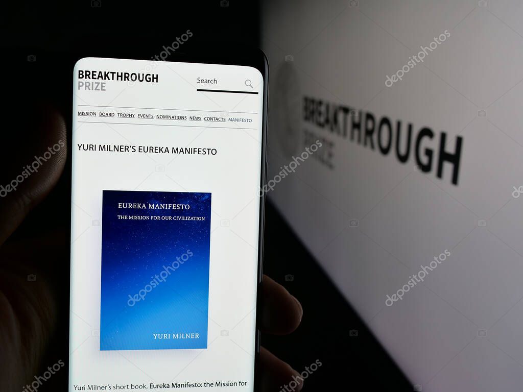 Stuttgart, Germany - 10-31-2025: Person holding cellphone with webpage of international awards Breakthrough Prizes on screen in front of logo. Focus on center of phone display.