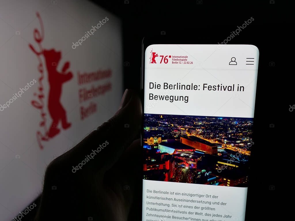 Stuttgart, Germany - 10-31-2025: Person holding cellphone with webpage of Berlin International Film Festival Berlinale on screen in front of logo. Focus on center of phone display.