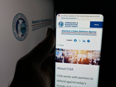 Stuttgart, Almanya - 11-02-2025: Logo önünde ekranda siber güvenlik ve altyapı ajansı CISA 'nın web sayfası bulunan cep telefonu sahibi kişi. Telefon ekranının merkezine odaklan.