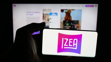Stuttgart, Almanya - 11-02-2025: Pazarlama şirketi IZEA Worldwide Inc 'in logosuna sahip cep telefonu web sayfası önünde ekranda. Telefon ekranına odaklan.