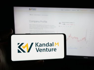 Stuttgart, Almanya - 11-02-2025: Çanta şirketi Kandal M Venture Limited 'in logosuna sahip akıllı telefon sahibi kişi web sitesinin önünde ekranda. Telefon ekranına odaklan.