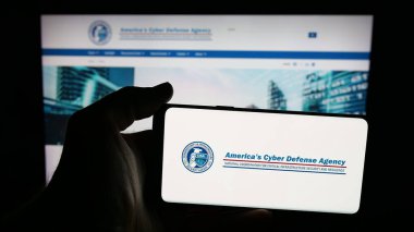 Stuttgart, Almanya - 11-02-2025: İnternet sayfasının önünde ekranda siber güvenlik ve altyapı kuruluşu CISA logosu bulunan cep telefonu sahibi kişi. Telefon ekranına odaklan.