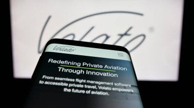 Stuttgart, Almanya - 11-02-2025: ABD 'li özel jet seyahat şirketi Volato Inc.' in web sitesi bulunan cep telefonu logonun önünde ekranda. Telefon ekranının sol üst kısmına odaklan.