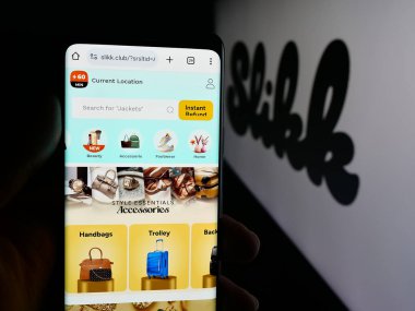 Stuttgart, Almanya - 11-02-2025: Hintli moda şirketi Slikk 'in internet sayfası ile akıllı telefon taşıyan kişi logonun önünde ekranda. Telefon ekranının merkezine odaklan.