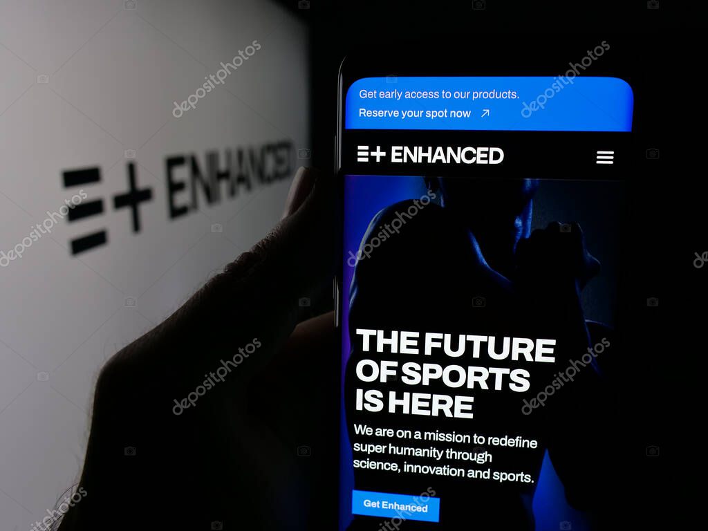 Stuttgart, Germany - 11-02-2025: Person holding smartphone with web page of multi-sport event Enhanced Games on screen in front of logo. Focus on center of phone display.