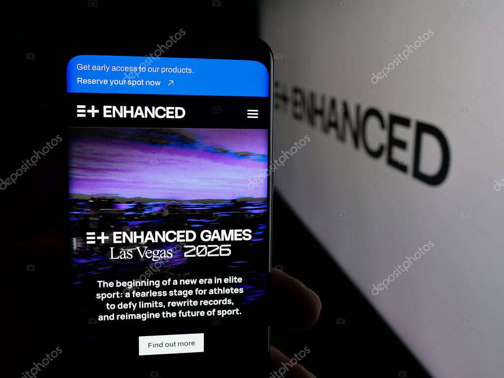 Stuttgart, Germany - 11-02-2025: Person holding cellphone with webpage of multi-sport event Enhanced Games on screen in front of logo. Focus on center of phone display.