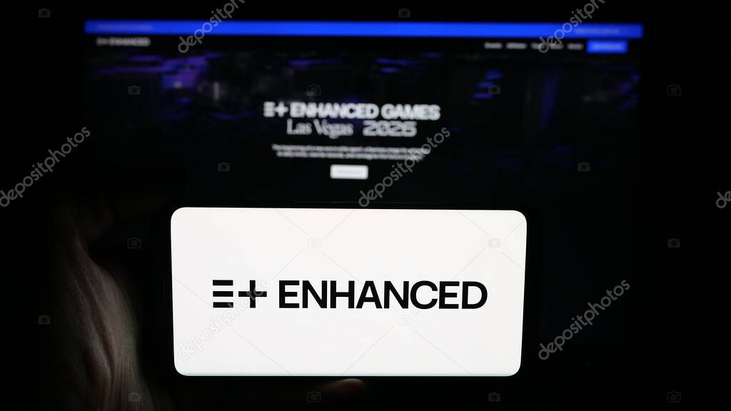 Stuttgart, Germany - 11-02-2025: Person holding cellphone with logo of multi-sport event Enhanced Games on screen in front of webpage. Focus on phone display.