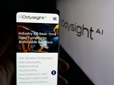 Stuttgart, Germany - 11-03-2025: Person holding cellphone with webpage of Israeli AI company OdysightAI Ltd. (Odysight) on screen in front of logo. Focus on center of phone display.
