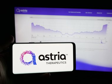Stuttgart, Germany - 11-03-2025: Person holding smartphone with logo of US pharma company Astria Therapeutics Inc. on screen in front of website. Focus on phone display.