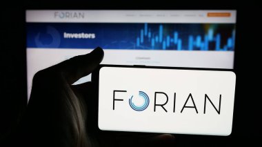 Stuttgart, Germany - 11-03-2025: Person holding mobile phone with logo of US software company Forian Inc. on screen in front of web page. Focus on phone display.