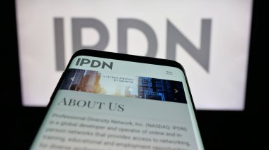 Stuttgart, Germany - 11-04-2025: Mobile phone with website of Professional Diversity Network Inc. (IPDN) on screen in front of logo. Focus on top-left of phone display.