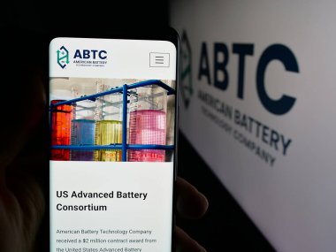 Stuttgart, Germany - 11-04-2025: Person holding smartphone with web page of American Battery Technology Company (ABTC) on screen in front of logo. Focus on center of phone display.