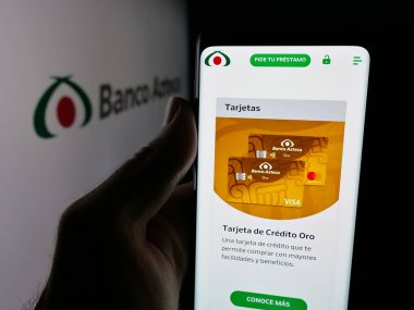 Stuttgart, Germany - 11-05-2025: Person holding smartphone with web page of Mexican financial company Banco Azteca on screen in front of logo. Focus on center of phone display.