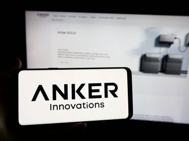 Stuttgart, Germany - 11-05-2025: Person holding smartphone with logo of Chinese company Anker Innovations Co. Ltd. on screen in front of website. Focus on phone display.