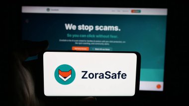 Stuttgart, Germany - 11-05-2025: Person holding cellphone with logo of US AI cybersecurity company ZoraSafe Inc. on screen in front of webpage. Focus on phone display.