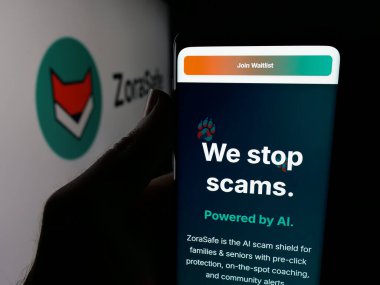 Stuttgart, Germany - 11-05-2025: Person holding cellphone with webpage of US AI cybersecurity company ZoraSafe Inc. on screen in front of logo. Focus on center of phone display.